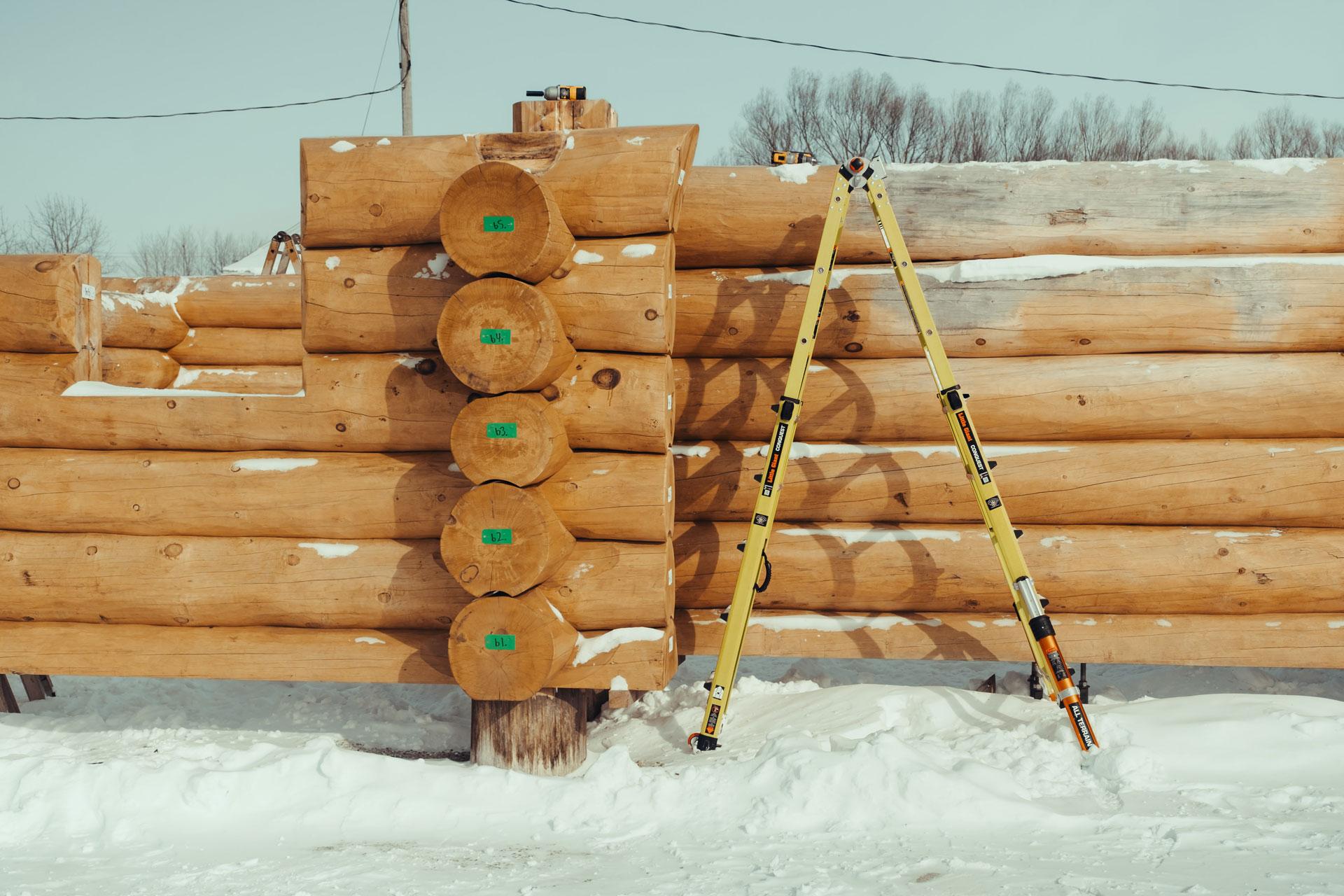 Numbered round logs stickered for transport at the Laverty Log Homes shop in Ontario